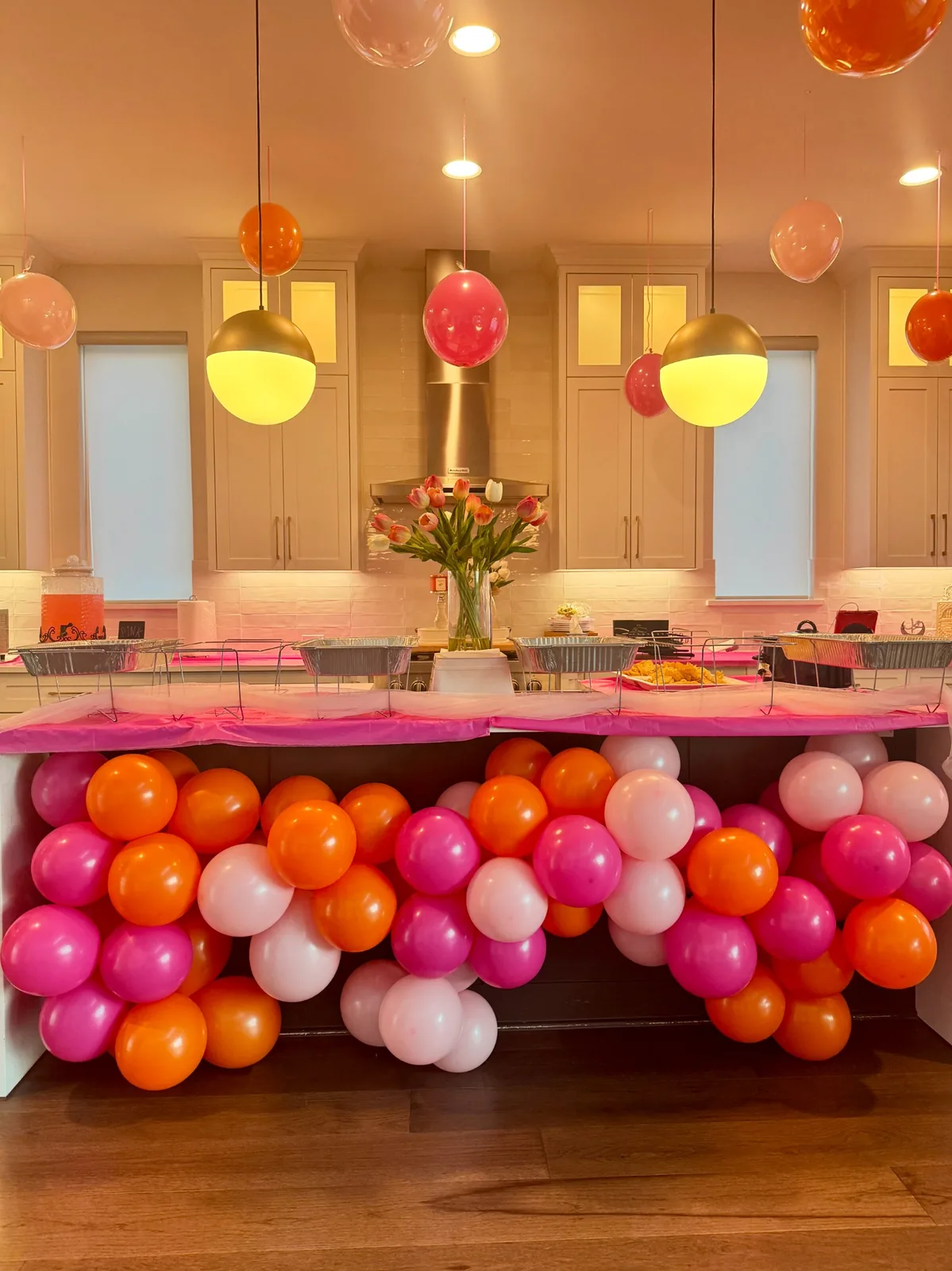 Pink, orange and blush balloon installation decorating buffet area